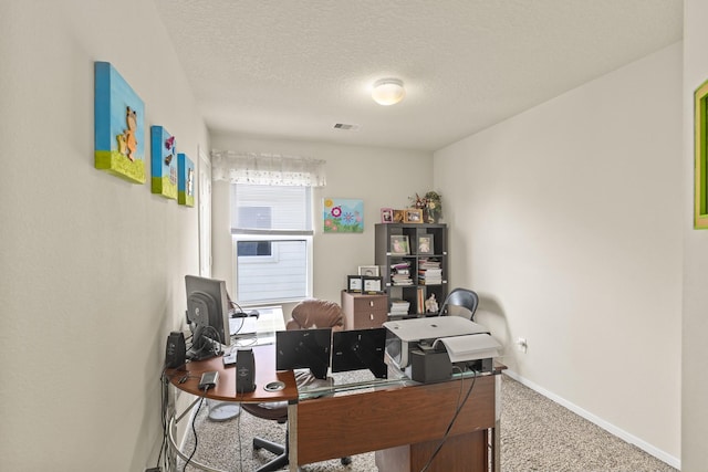 office area with carpet floors, a textured ceiling, visible vents, and baseboards