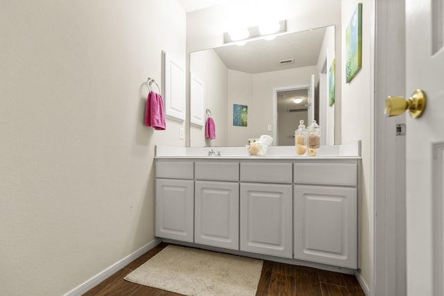 bathroom featuring baseboards, wood finished floors, visible vents, and vanity
