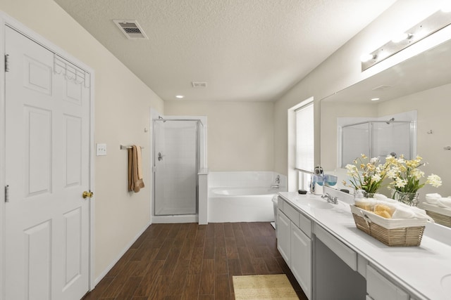 full bath featuring a shower stall, wood finished floors, a bath, and vanity