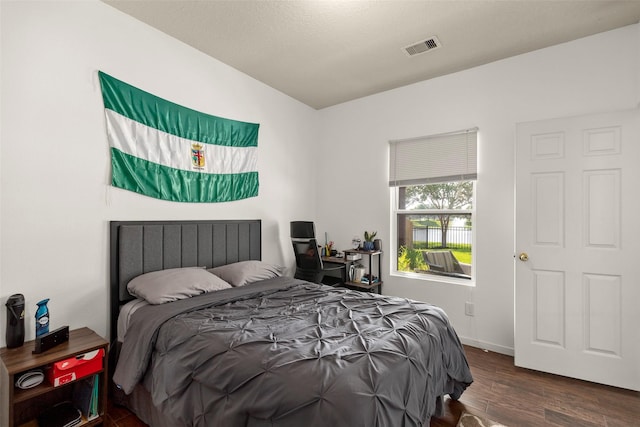 bedroom with visible vents and wood finished floors