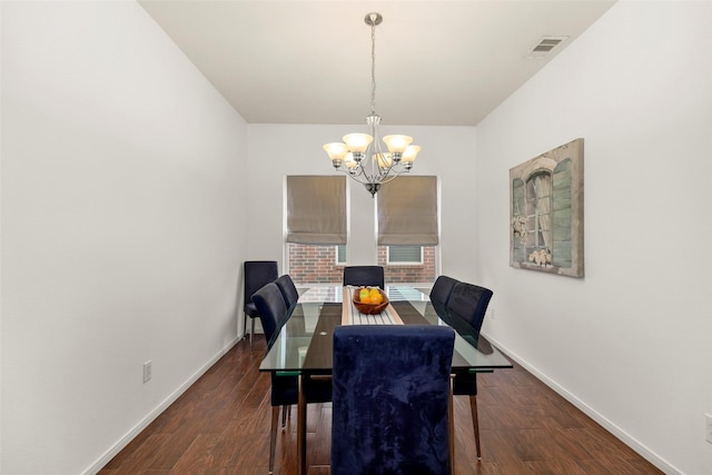 dining area featuring visible vents, baseboards, wood finished floors, and a chandelier