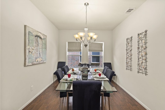 dining space with baseboards, an inviting chandelier, wood finished floors, and visible vents