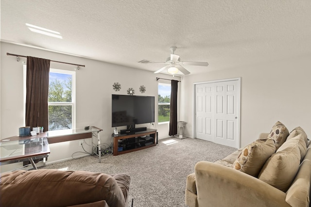 carpeted living room featuring visible vents, a ceiling fan, a textured ceiling, and plenty of natural light