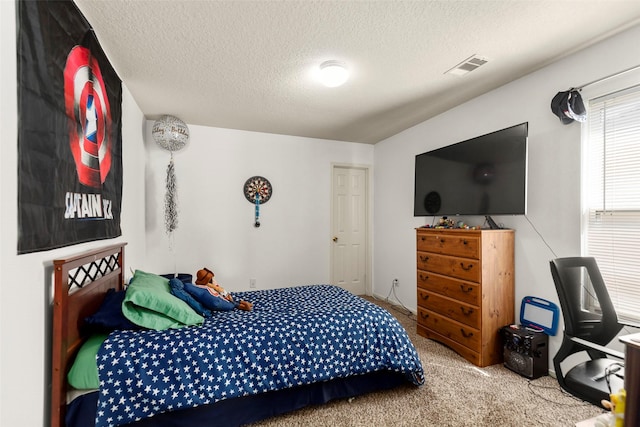 bedroom featuring a textured ceiling, visible vents, and carpet