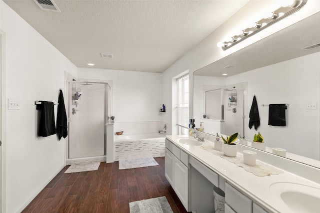 full bathroom featuring a sink, double vanity, visible vents, a garden tub, and a stall shower