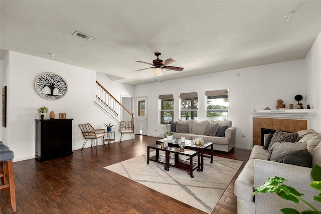 19527 Hardwood Ridge Trl, Cypress, TX 77429 - living room featuring stairway, a ceiling fan, wood finished floors, a tile fireplace, and a textured ceiling
