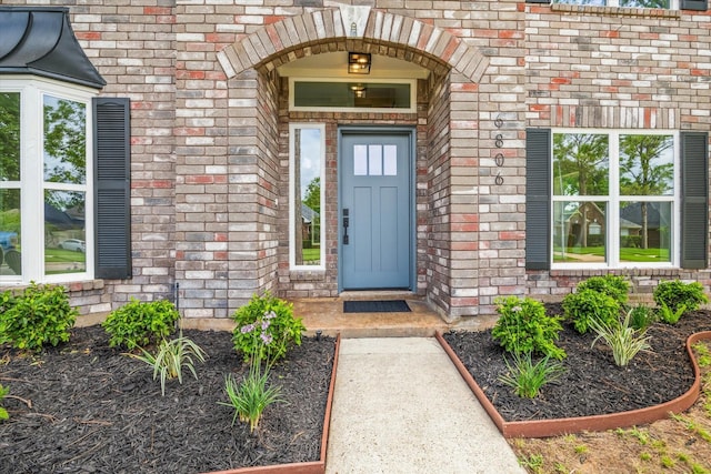 doorway to property featuring brick siding