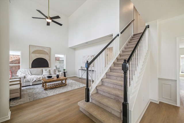 living area featuring high vaulted ceiling, stairs, wood finished floors, and a wealth of natural light