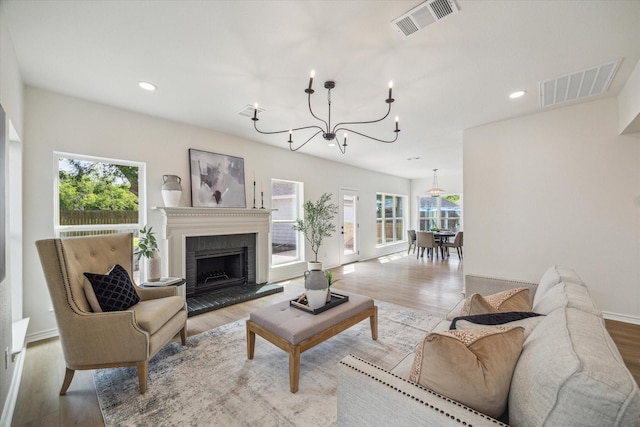 living room featuring visible vents, plenty of natural light, and an inviting chandelier