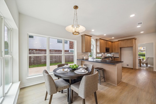 dining area featuring plenty of natural light, light wood-type flooring, and visible vents