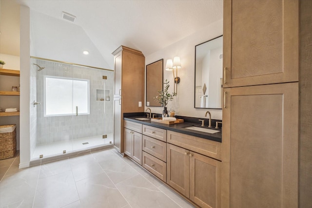 full bathroom featuring a sink, a stall shower, and lofted ceiling