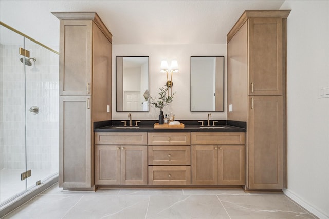 bathroom with double vanity, baseboards, a shower stall, and a sink