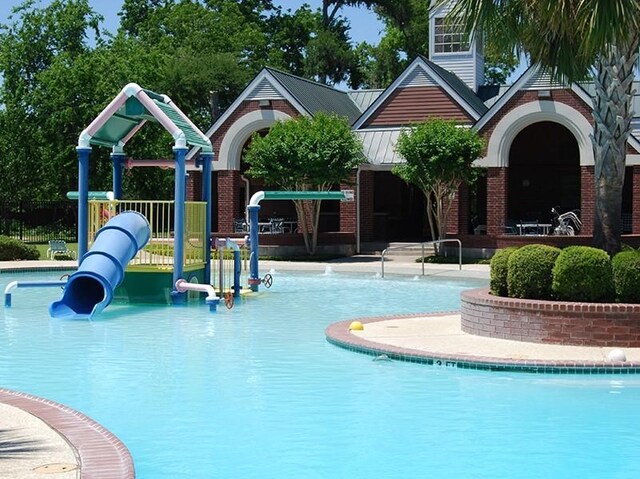 pool with a water play area and playground community