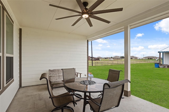 view of patio with ceiling fan, fence, and outdoor dining area