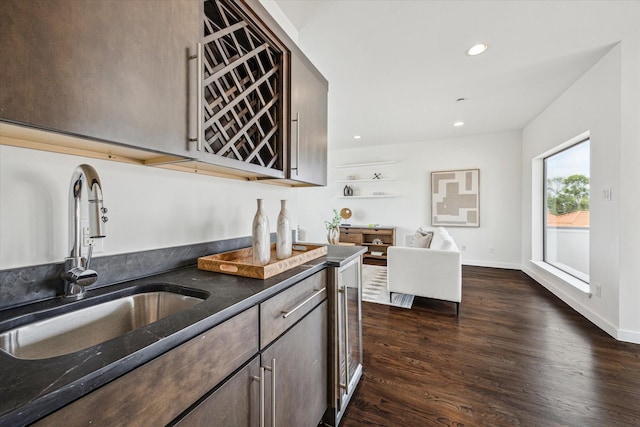 kitchen featuring dark brown cabinets, a sink, dark stone countertops, dark wood-style floors, and recessed lighting