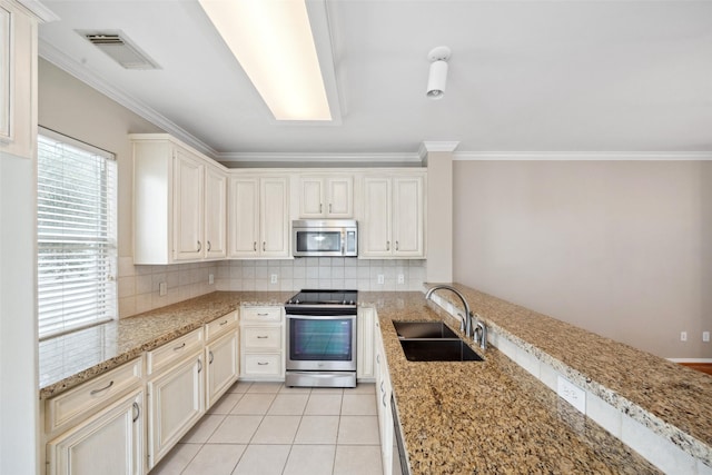 kitchen featuring visible vents, decorative backsplash, ornamental molding, a sink, and stainless steel appliances