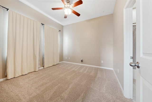 carpeted spare room with baseboards and a ceiling fan