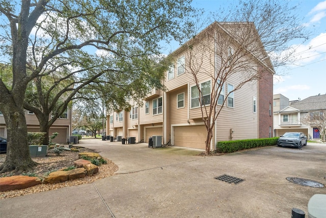 view of home's exterior with an attached garage, cooling unit, and driveway
