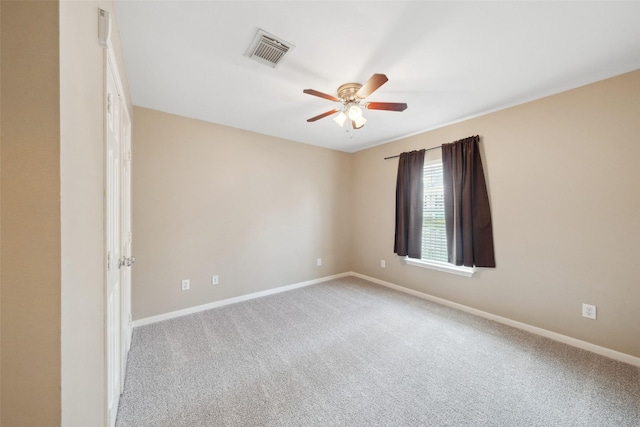 carpeted empty room with visible vents, baseboards, and ceiling fan