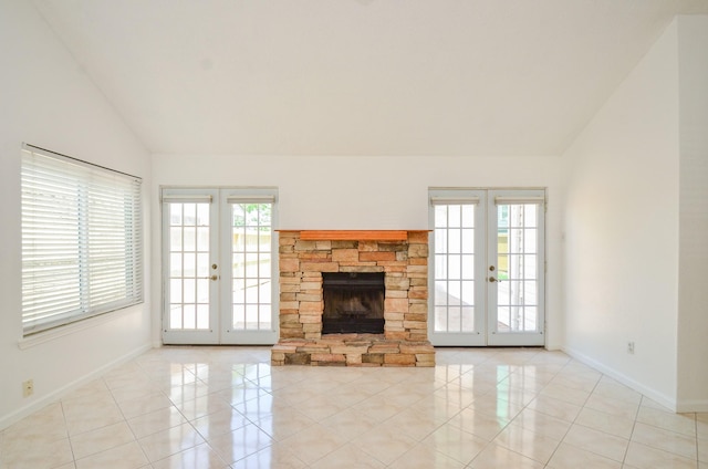 unfurnished living room with light tile patterned floors, baseboards, vaulted ceiling, and french doors