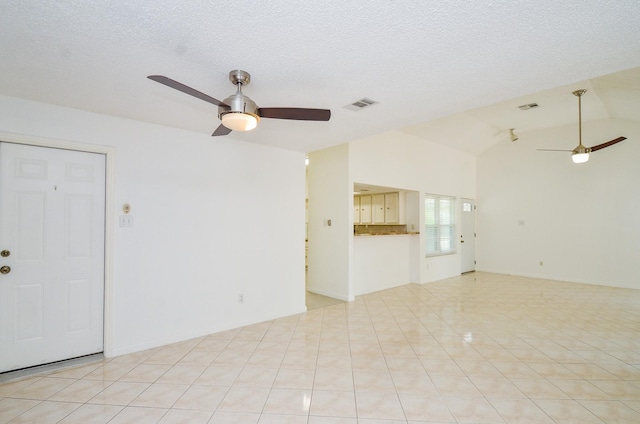 unfurnished living room with ceiling fan, vaulted ceiling, and visible vents