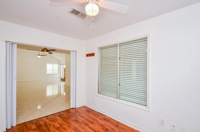 unfurnished room featuring visible vents, a ceiling fan, baseboards, and wood finished floors