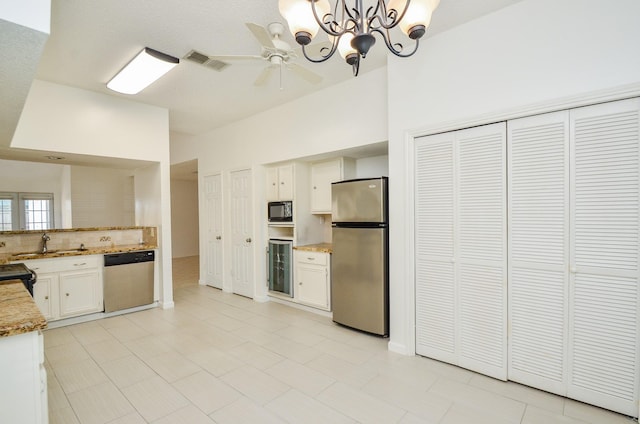 kitchen with decorative backsplash, visible vents, white cabinets, ceiling fan with notable chandelier, and black appliances