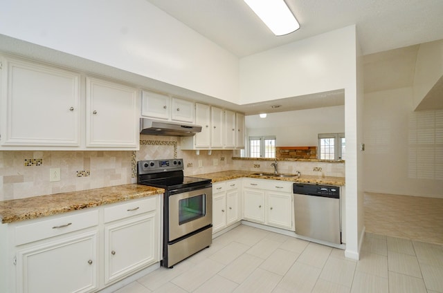 kitchen with under cabinet range hood, white cabinets, tasteful backsplash, a sink, and stainless steel appliances