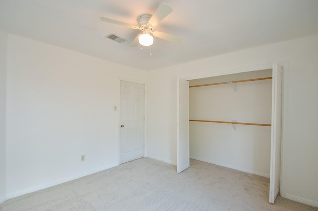unfurnished bedroom featuring a ceiling fan, light colored carpet, visible vents, and a closet