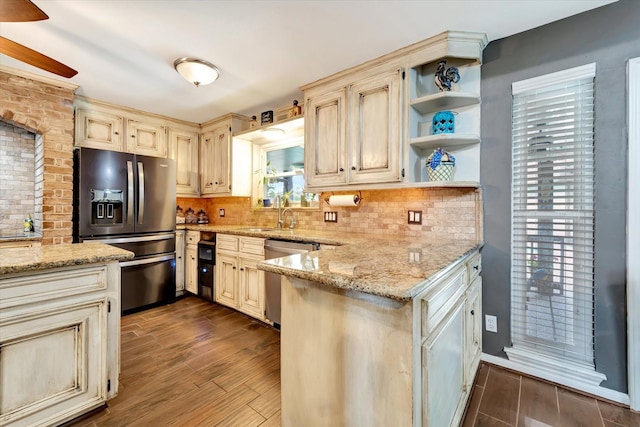 kitchen featuring cream cabinets, dark wood-style flooring, tasteful backsplash, stainless steel dishwasher, and refrigerator with ice dispenser