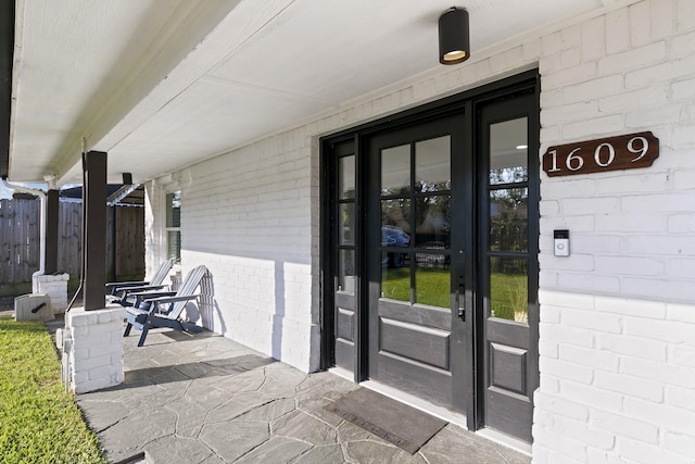 1609 Tabor St, Houston, TX 77009 - doorway to property featuring brick siding, fence, and french doors