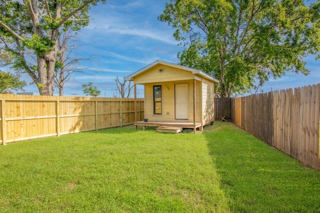 view of outdoor structure featuring a fenced backyard and an outbuilding