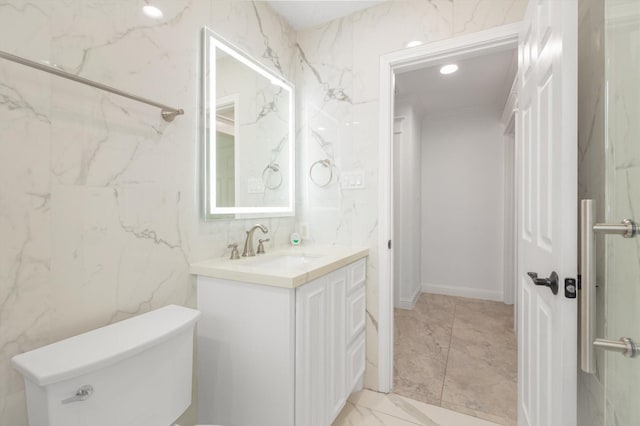 bathroom featuring toilet, recessed lighting, marble finish floor, and vanity