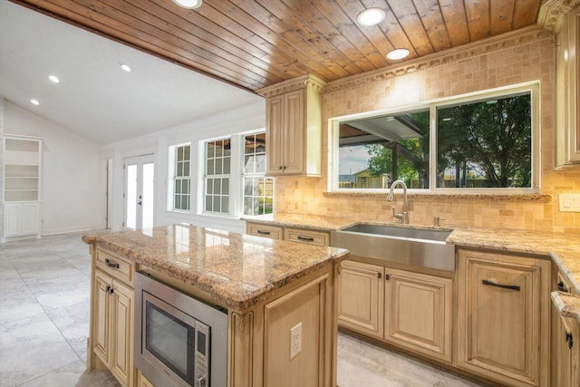 kitchen featuring recessed lighting, a sink, decorative backsplash, and stainless steel microwave