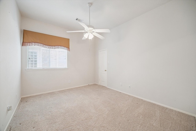 empty room with baseboards, a ceiling fan, carpet flooring, and visible vents