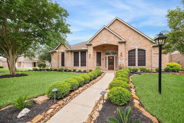 view of front of house featuring a front lawn and brick siding