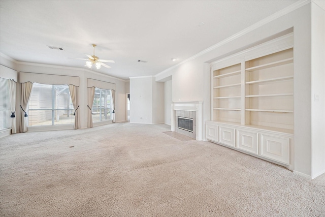 unfurnished living room featuring crown molding, a ceiling fan, visible vents, a fireplace, and carpet flooring