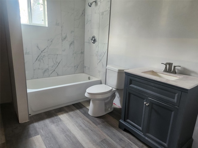 bathroom with toilet, bathing tub / shower combination, wood finished floors, and vanity