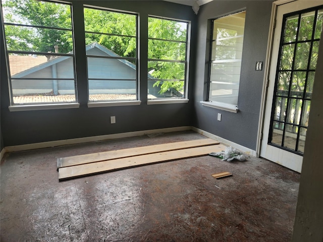 empty room featuring a healthy amount of sunlight and baseboards