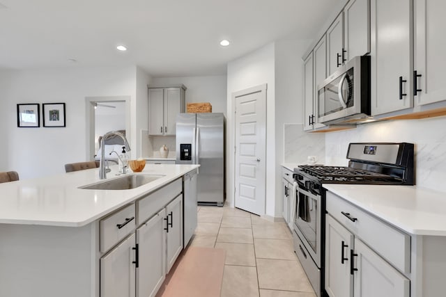 29823 Case Canyon Ln, Katy, TX 77494 - kitchen featuring backsplash, a sink, light countertops, stainless steel appliances, and an island with sink