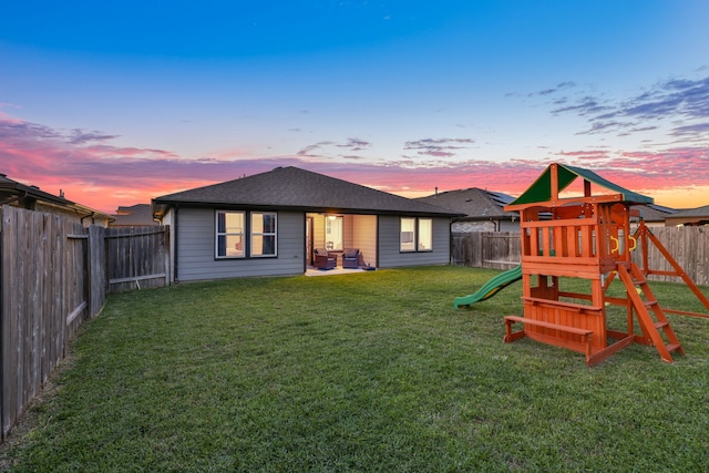 29823 Case Canyon Ln, Katy, TX 77494 - back of property featuring a lawn, a fenced backyard, a playground, and roof with shingles