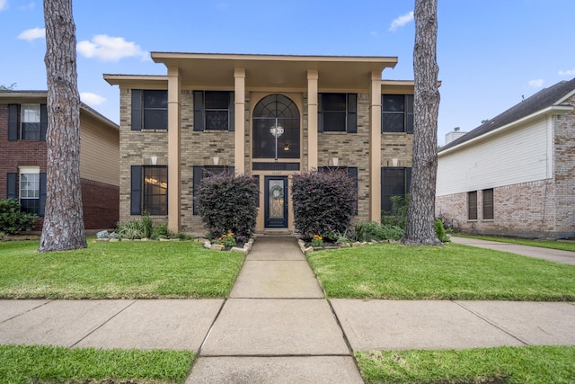 view of front of house with a front lawn and brick siding