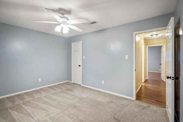 unfurnished bedroom featuring baseboards, a ceiling fan, visible vents, and carpet floors
