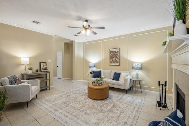 living area with light tile patterned floors, visible vents, a fireplace, and ceiling fan