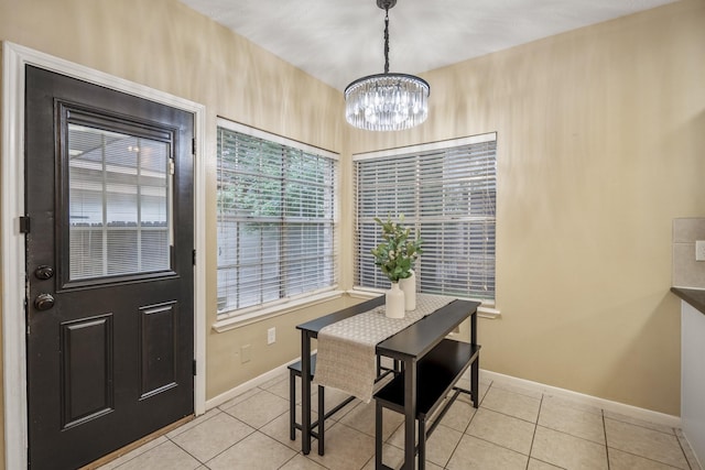 dining room with baseboards, a chandelier, and light tile patterned flooring