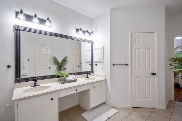 full bath featuring a sink, double vanity, baseboards, and tile patterned floors
