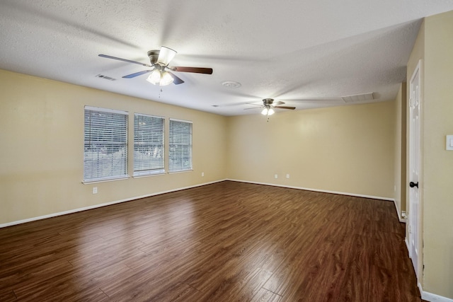 unfurnished room featuring ceiling fan, a textured ceiling, visible vents, and dark wood finished floors
