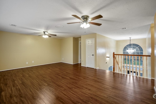 empty room featuring baseboards, visible vents, wood finished floors, and ceiling fan with notable chandelier