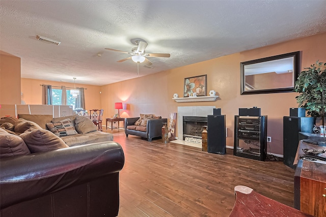 10834 Glenora Dr, Houston, TX 77065 - living room featuring visible vents, wood finished floors, a textured ceiling, a tile fireplace, and a ceiling fan