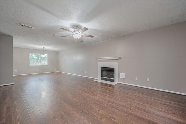 10834 Glenora Dr, Houston, TX 77065 - unfurnished living room featuring a ceiling fan, a fireplace, a textured ceiling, and dark wood-style flooring